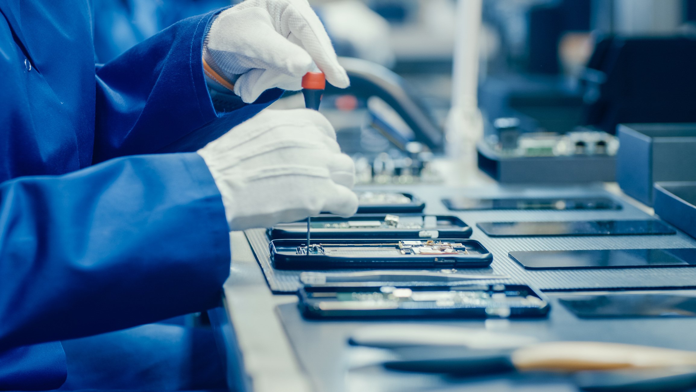 Electronics factory worker assembling a smartphone.