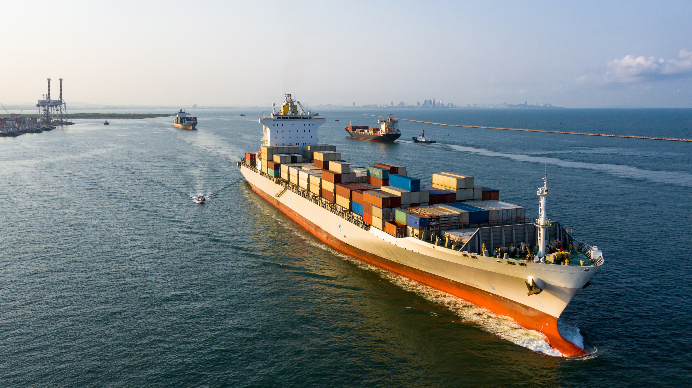 Shipping vessel leaving harbour full on shipping containers.