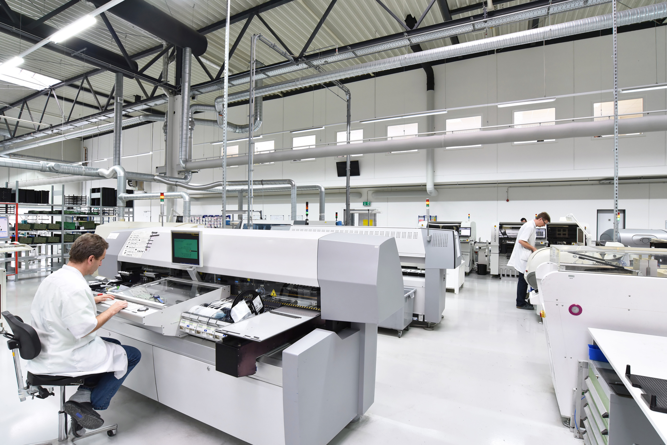 Two staff members working in an electronic manufacturing plant.