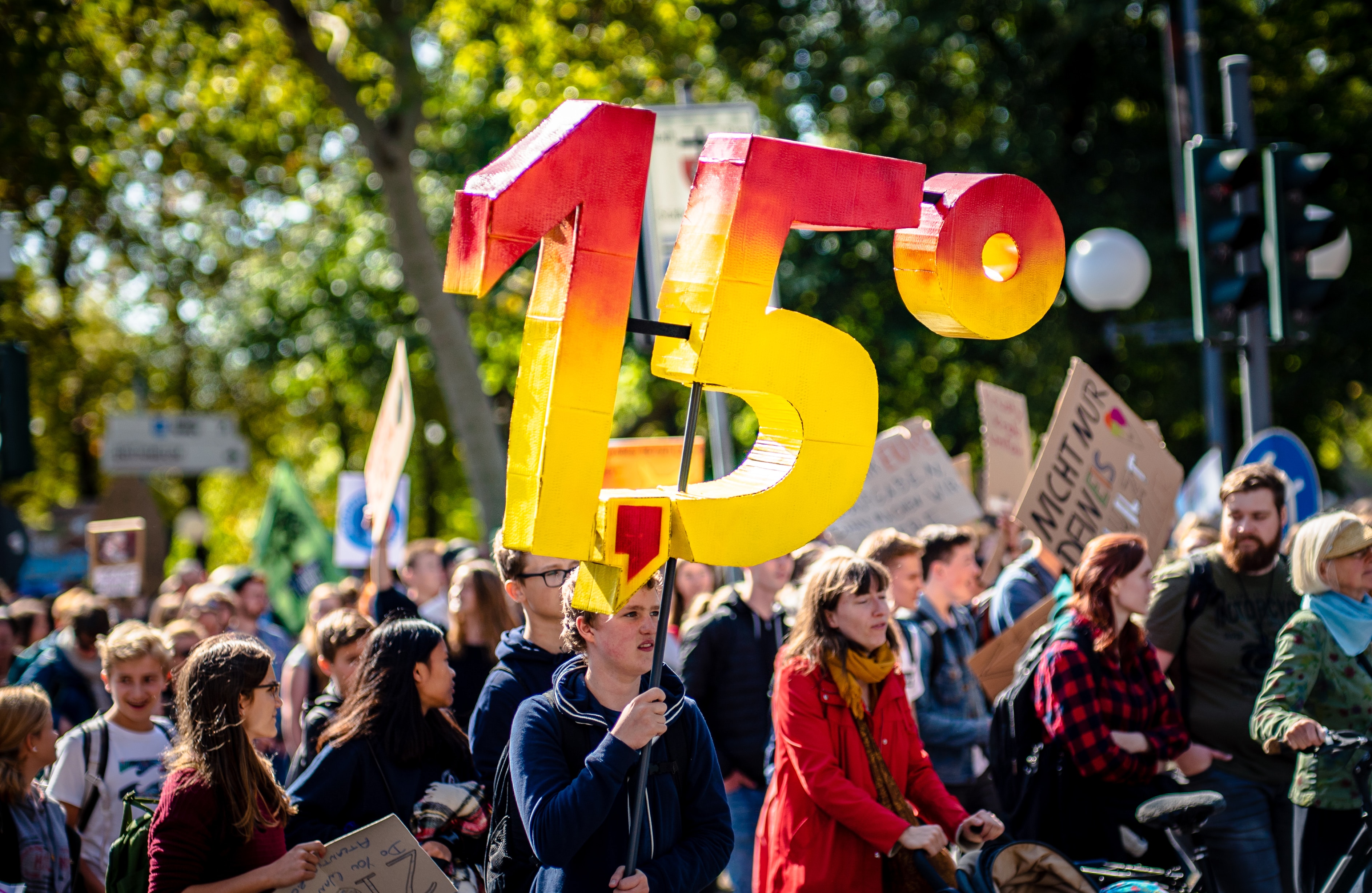 Protester in a crowd holding a sign that says 1.5 degrees.