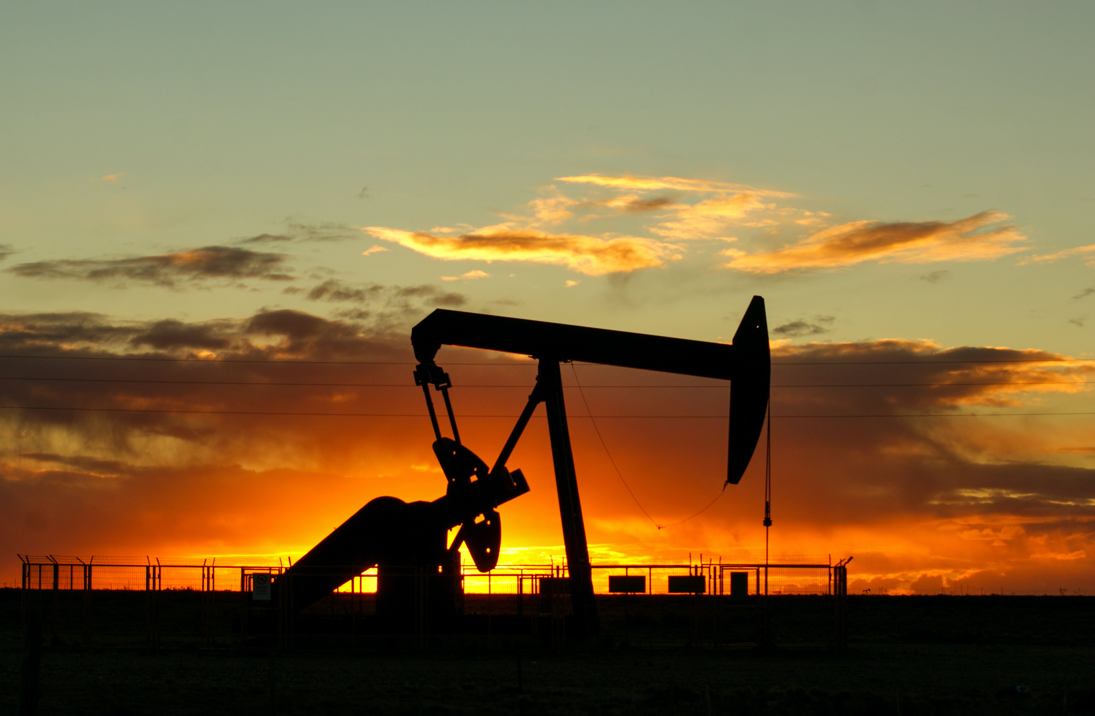 Silhouette of a piece of mining equipment with the sun setting in the background.